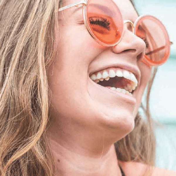 Happy blonde woman laughing wearing orange glasses